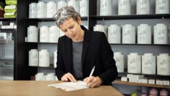 Female shop owner taking notes on paper