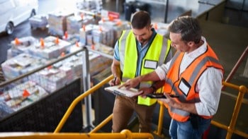 Men in warehouse reviewing clipboards