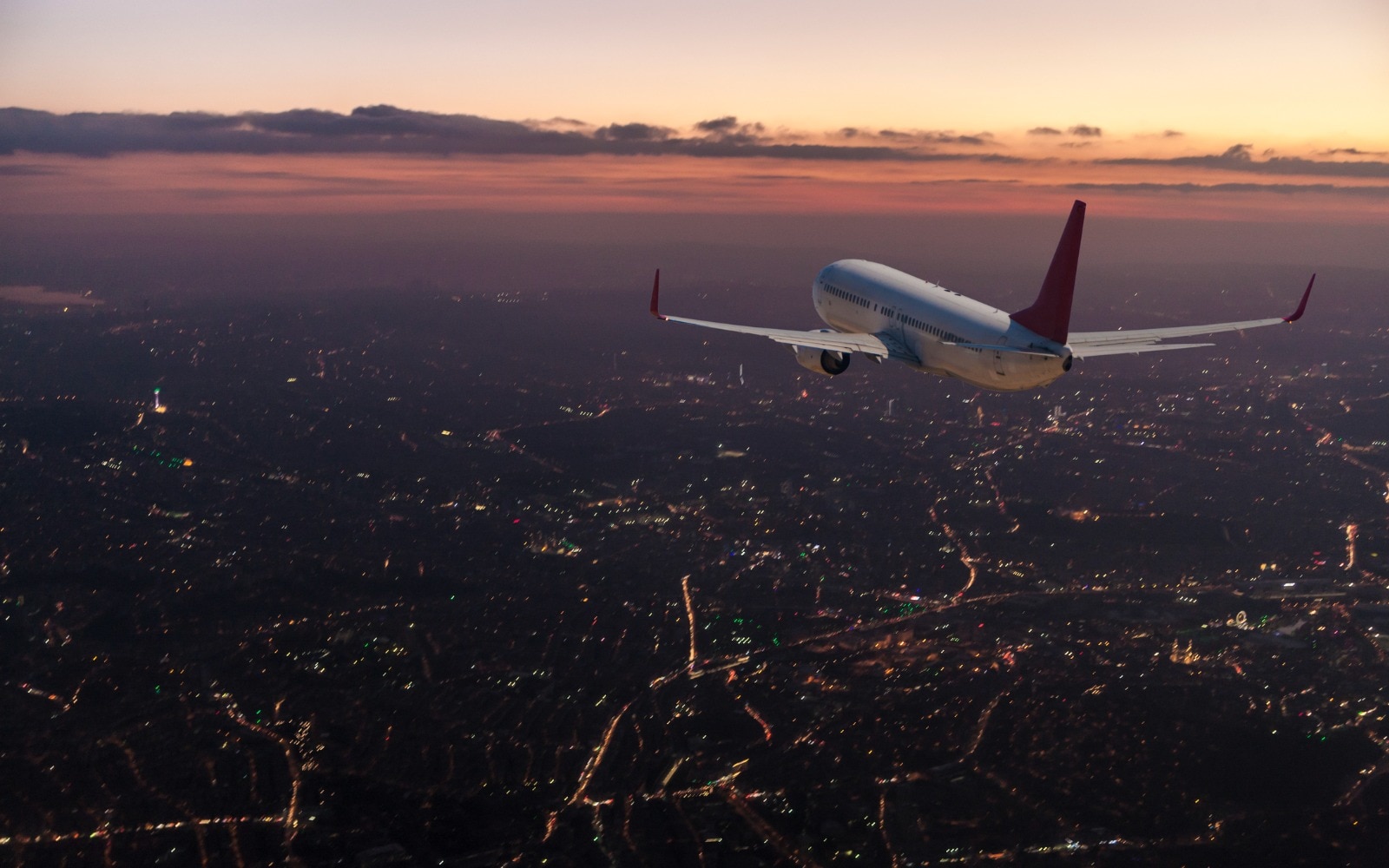 commercial airplane flying over city