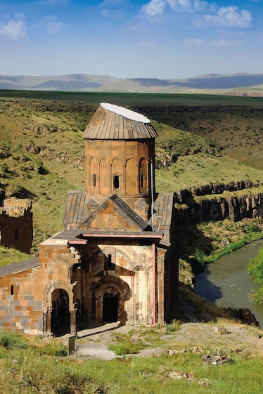 a cathedral next to a river with no other buildings in sight