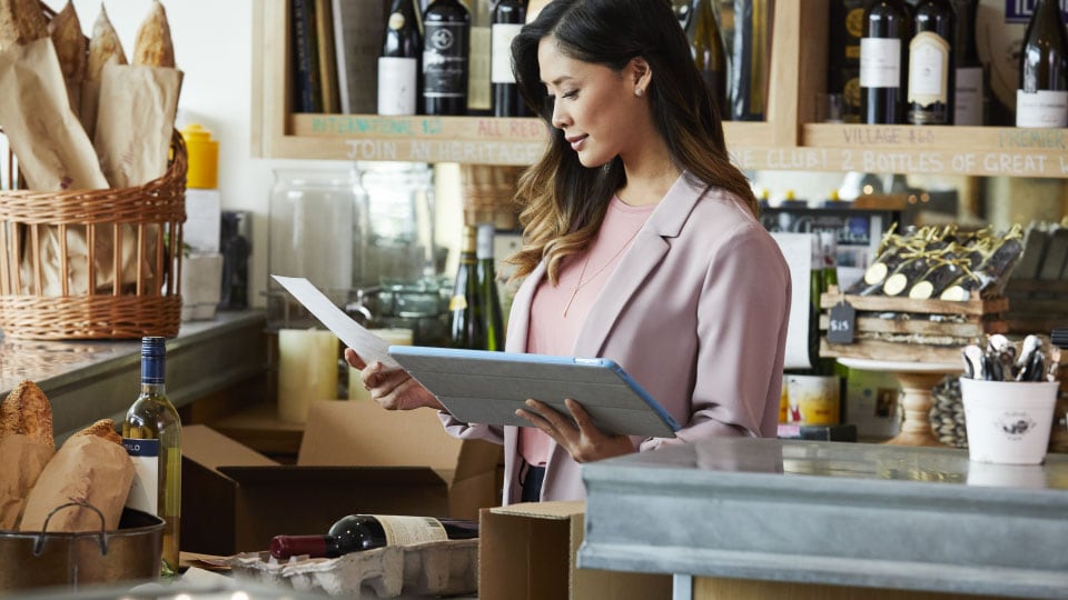 Woman in shop looking at tablet computer