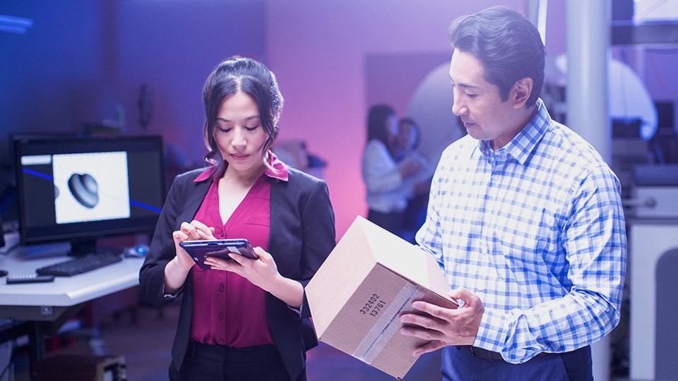 Two small business owners in an office sending package. 