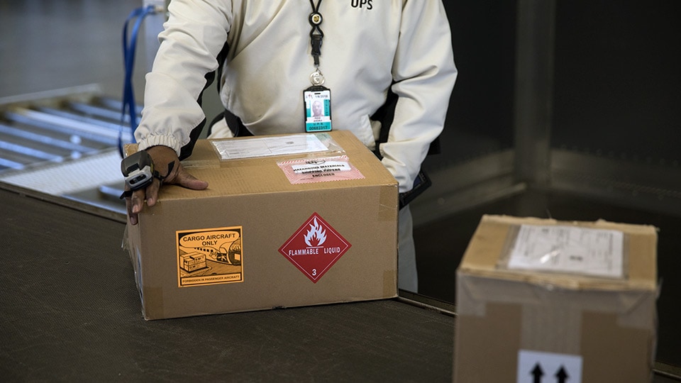 UPS worker holding a box with flammable liquid