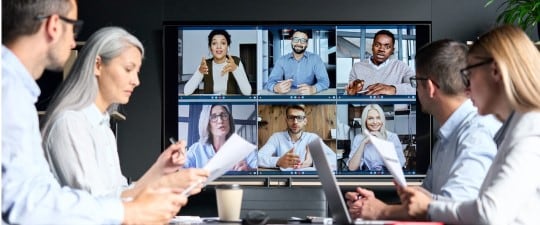 Workers in conference room on video call