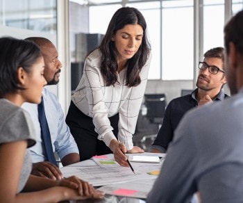 Woman in meeting pointing at paper