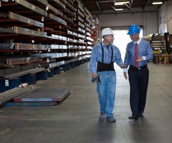 Warehouse worker and businessman in hard hats