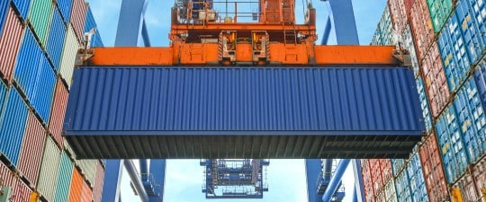 Shipping container being raised at port