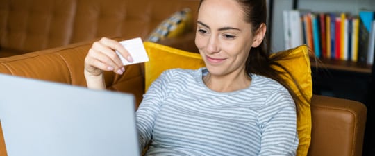 Happy woman shopping on couch