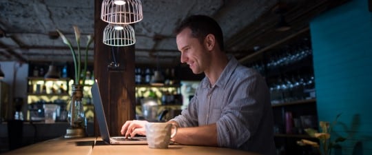 Man using computer in restaurant at night