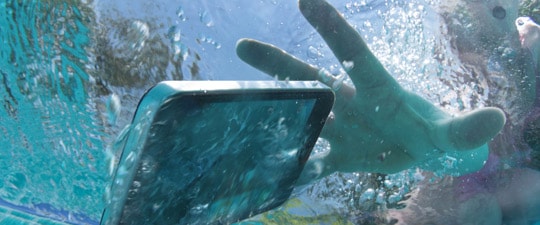 Woman dropping smartphone in pool