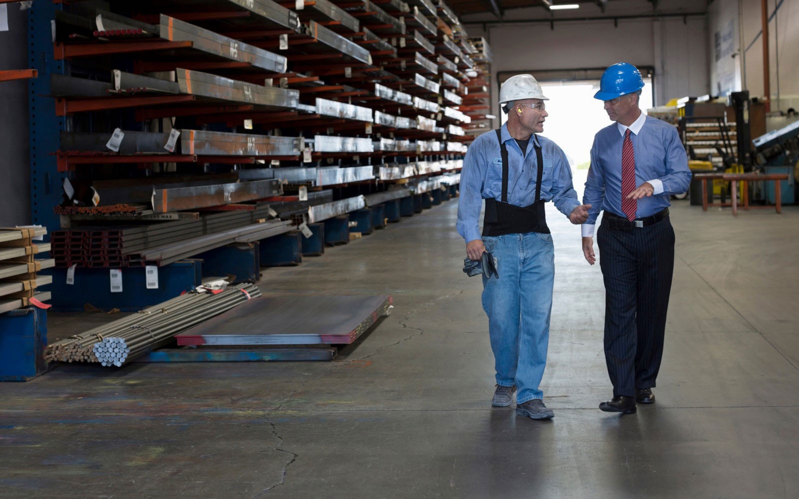 Men in hard hats walking through warehouse