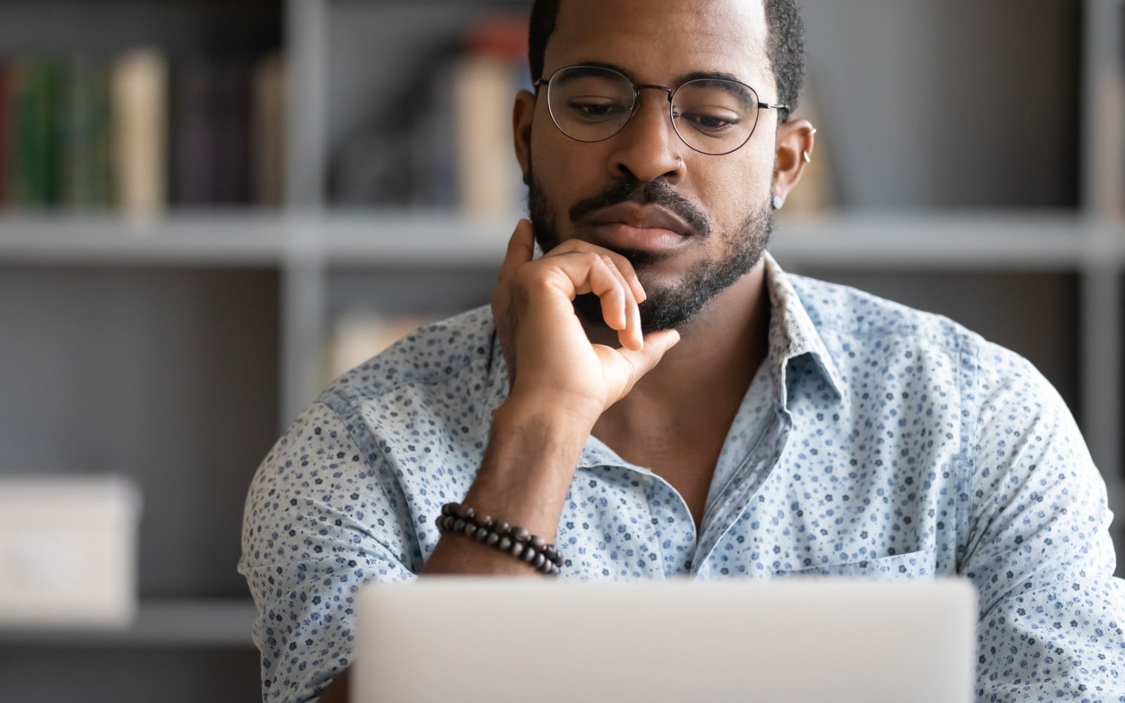 Man staring at computer in serious thought