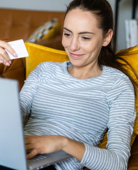 Happy woman shopping on couch