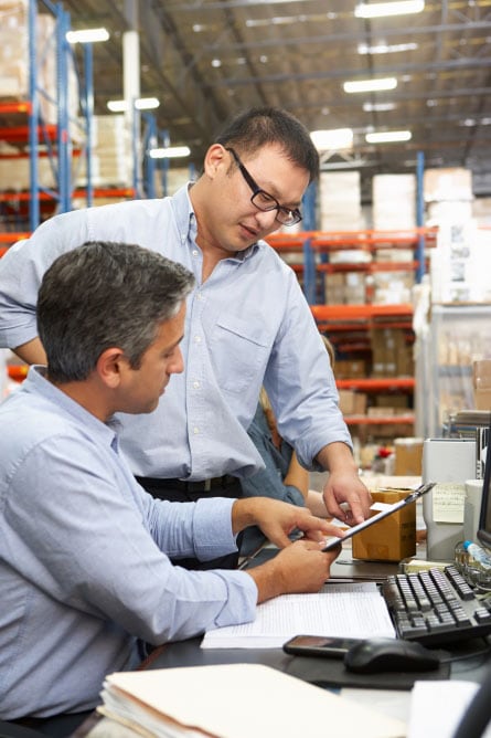 Men in warehouse using tablet