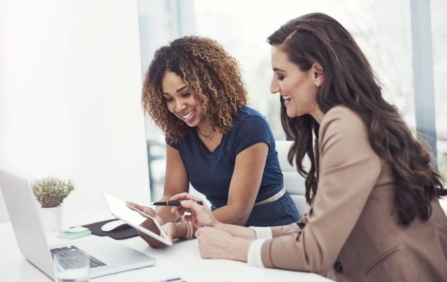 Two businesswomen working together on a tablet