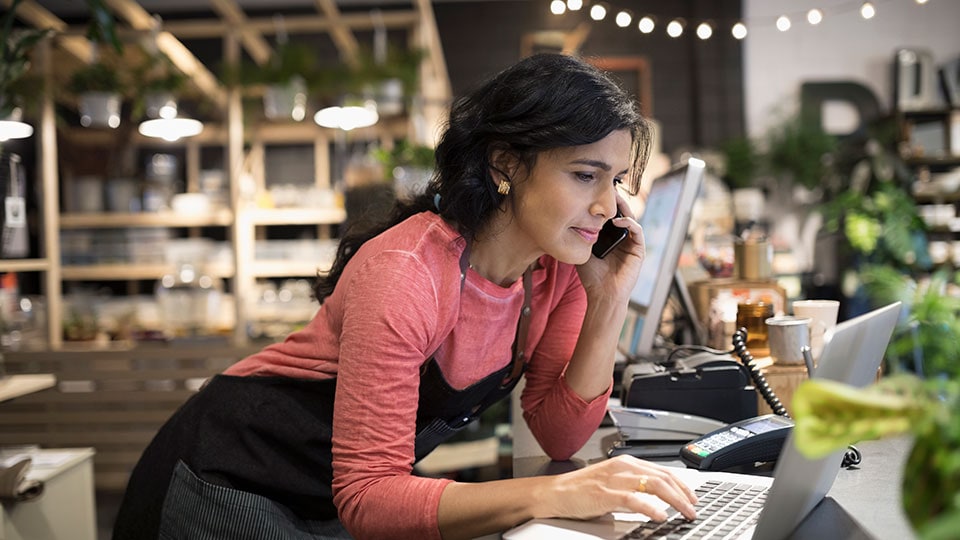 Woman on the phone using a laptop