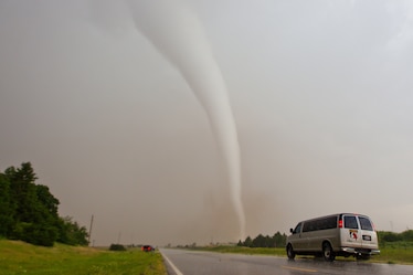 Storm chasers stop near a tornado formed under a supercell thunderstorm.