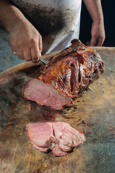 Steam rises from fresh slices of pit barbecue beef.