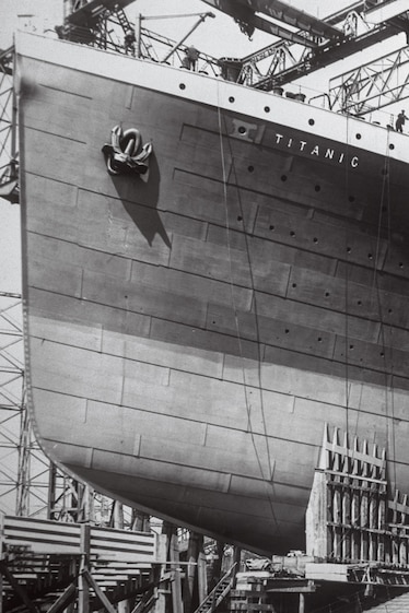 Photo of very large ship hull with scaffolding around it.