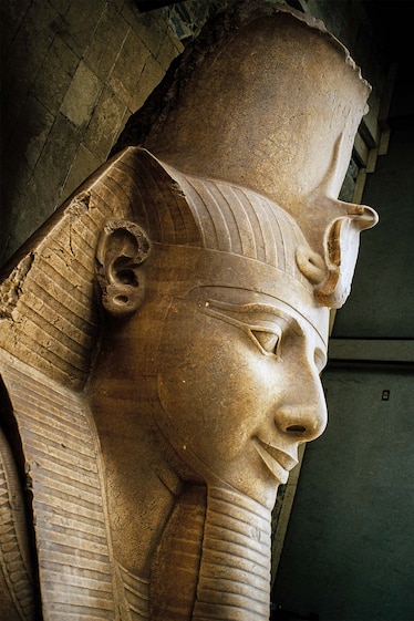 The head of Ramses II’s recumbent colossus at Memphis wears the nemes, or striped head cloth, and the royal uraeus serpent of divinity and authority.