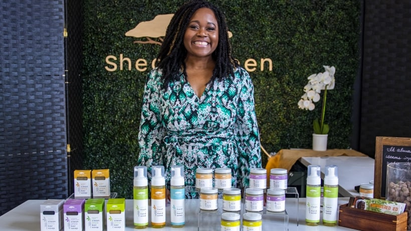 Shea Yeleen standing behind a table with her beauty products