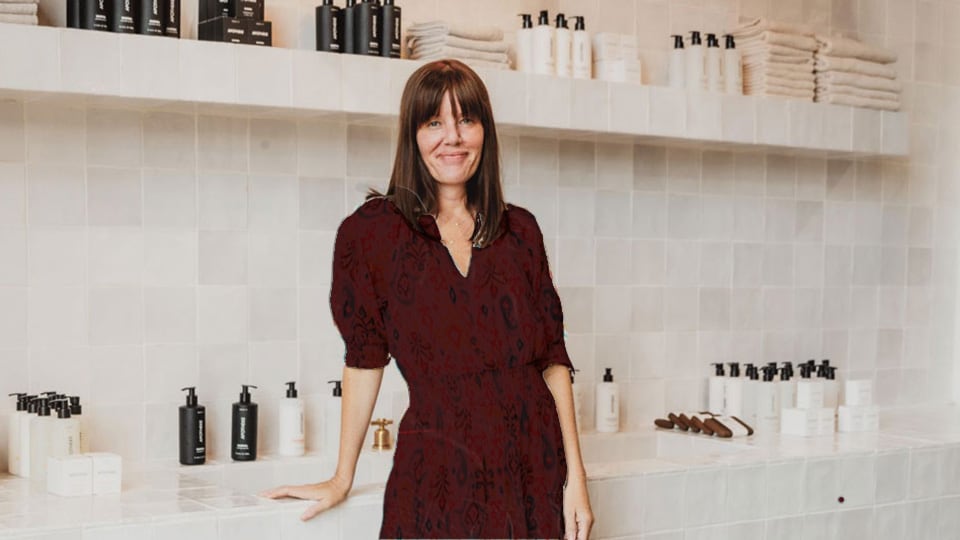 Chrissy, the owner of Apotheke, standing in frount of her products in her store.