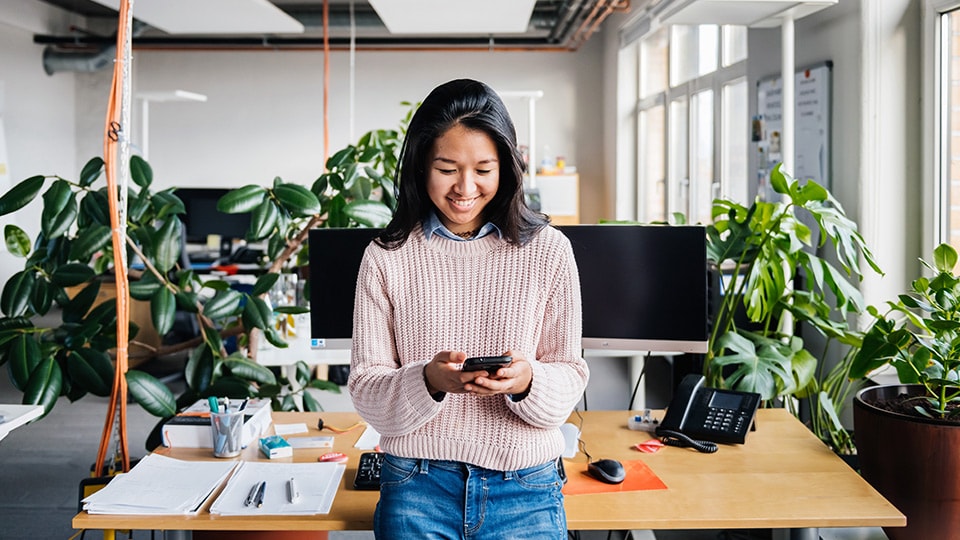  Woman in office looking at mobile phone